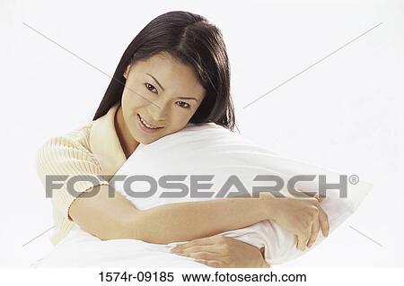 Portrait of a young woman holding a pillow smiling View Large Photo Image Stock Photography - Portrait of a young woman holding a pillow smiling. Fotosearch