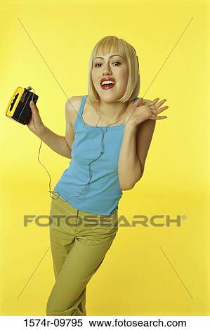 Stock Photography - Portrait of a young woman holding a music player. Fotosearch