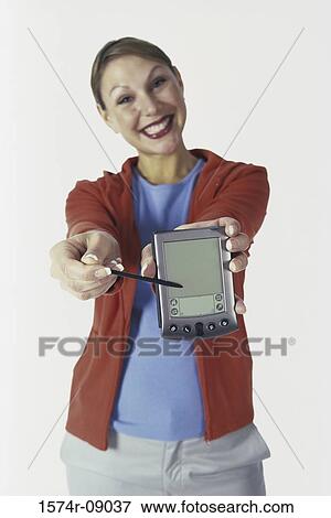 Stock Photo - Portrait of a young woman holding out a hand held device. Fotosearch