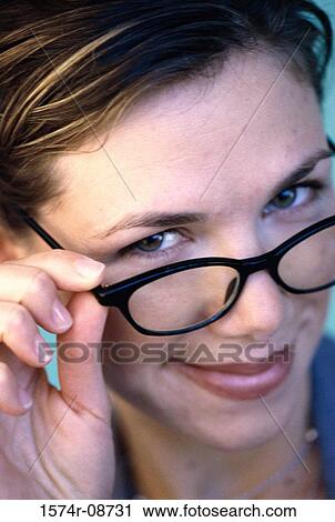 Portrait of a young woman holding eyeglasses View Large Photo Image Stock Image - Portrait of a young woman holding eyeglasses. Fotosearch