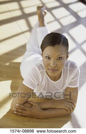 Stock Photo - Portrait of a young woman lying on the floor. Fotosearch