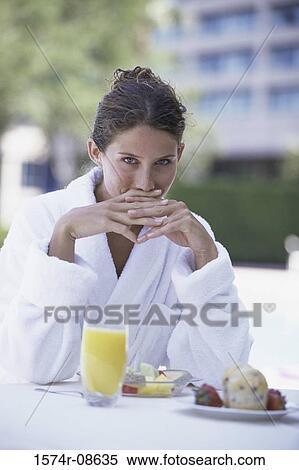 Portrait of a young woman sitting at a table View Large Photo Image Stock Photography - Portrait of a young woman sitting at a table. Fotosearch