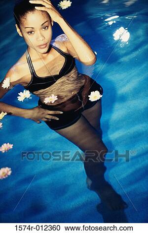 Portrait of a young woman standing in a swimming pool View Large Photo Image Stock Image - Portrait of a young woman standing in a swimming pool. Fotosearch