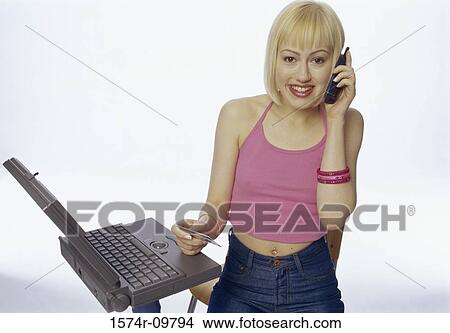 Portrait of a young woman talking on a mobile phone holding a credit card View Large Photo Image Picture - Portrait of a young woman talking on a mobile phone holding a credit card. Fotosearch