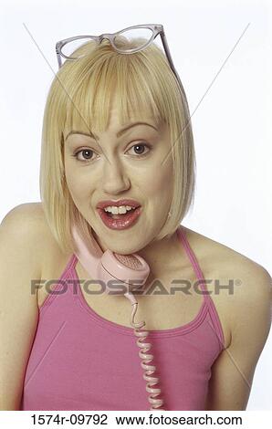 Stock Image - Portrait of a young woman talking on a telephone. Fotosearch