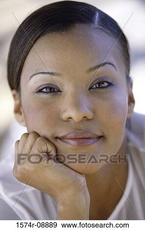 Stock Photo - Portrait of a young woman with her hand on her chin. Fotosearch