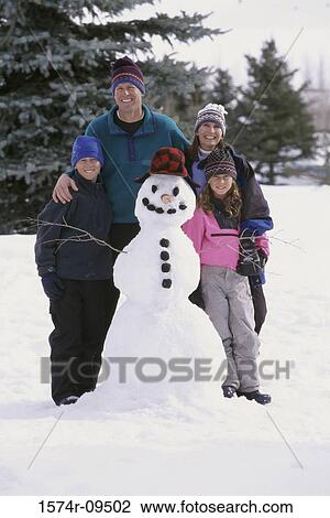 Portrait of parents and their children standing near a snowman View Large Photo Image Stock Image - Portrait of parents and their children standing near a snowman. Fotosearch