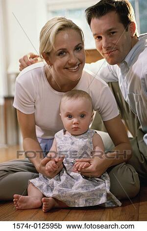 Portrait of parents sitting with their daughter View Large Photo Image Stock Image - Portrait of parents sitting with their daughter. Fotosearch