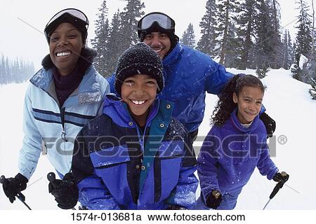 Stock Image - Portrait of parents with their son and daughter skiing. Fotosearch