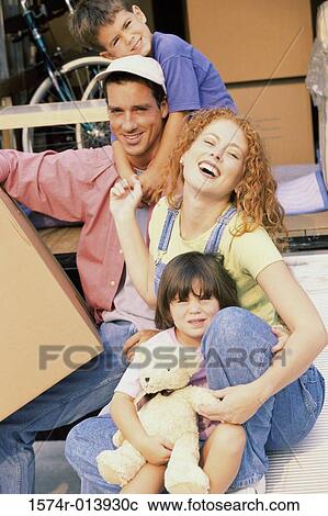 Stock Image - Portrait of parents with their son and daughter in their new home. Fotosearch