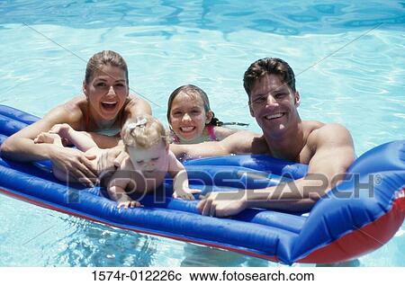 Portrait of parents with their two daughters on a pool raft in a swimming pool View Large Photo Image Stock Image - Portrait of parents with their two daughters on a pool raft in a swimming pool. Fotosearch