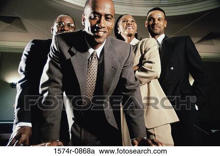 Stock Image - Portrait of three businessmen and a businesswoman smiling. Fotosearch
