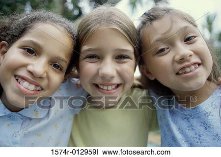 Stock Image - Portrait of three girls smiling. Fotosearch