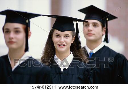 Stock Image - Portrait of three young graduates standing in a row. Fotosearch