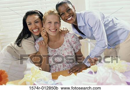 Stock Image - Portrait of three young women smiling at a baby shower. Fotosearch