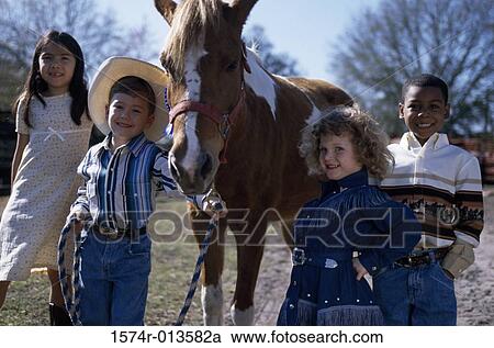 Portrait of two boys and two girls standing with a horse View Large Photo Image Stock Image - Portrait of two boys and two girls standing with a horse. Fotosearch
