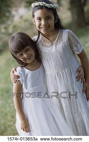 Stock Image - Portrait of two girls with their arms around each other. Fotosearch