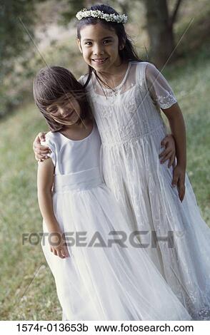 Stock Image - Portrait of two girls with their arms around each other. Fotosearch