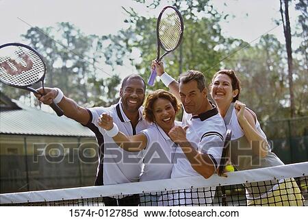 Stock Image - Portrait of two mid adult couples cheering. Fotosearch