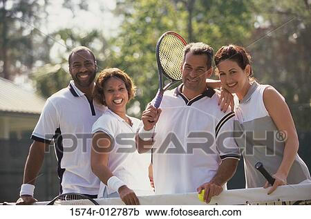 Portrait of two mid adult couples smiling on a tennis court View Large Photo Image Stock Image - Portrait of two mid adult couples smiling on a tennis court. Fotosearch