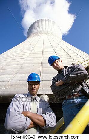 Portrait of two workers standing beside a smoke stack at a power plant View Large Photo Image Stock Photo - Portrait of two workers standing beside a smoke stack at a power plant. Fotosearch