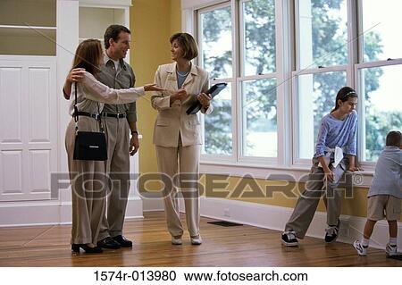 Real estate agent showing a house to a family View Large Photo Image Stock Image - Real estate agent showing a house to a family. Fotosearch