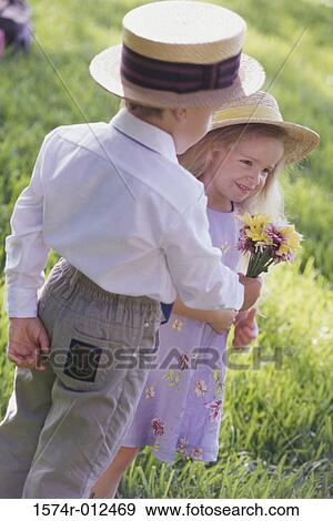 Rear view of a boy giving a bouquet of flowers to a girl View Large Photo Image Stock Photo - Rear view of a boy giving a bouquet of flowers to a girl. Fotosearch