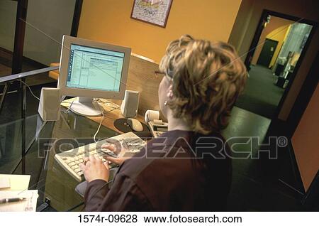 Rear view of a businesswoman working on a computer View Large Photo Image Stock Photo - Rear view of a businesswoman working on a computer. Fotosearch