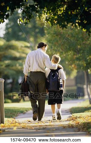 Rear view of a father walking with his son View Large Photo Image Stock Image - Rear view of a father walking with his son. Fotosearch