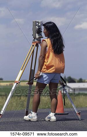 Rear view of a female surveyor working View Large Photo Image Stock Image - Rear view of a female surveyor working. Fotosearch