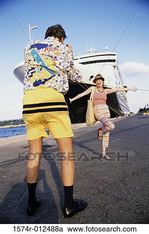 Rear view of a mid adult man taking a photograph of a mid adult woman View Large Photo Image Stock Image - Rear view of a mid adult man taking a photograph of a mid adult woman. Fotosearch