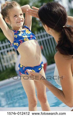 Rear view of a mother applying suntan lotion on her daughter View Large Photo Image Stock Image - Rear view of a mother applying suntan lotion on her daughter. Fotosearch