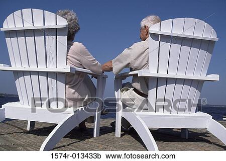 Rear view of a senior couple sitting in deck chairs View Large Photo Image Stock Image - Rear view of a senior couple sitting in deck chairs. Fotosearch