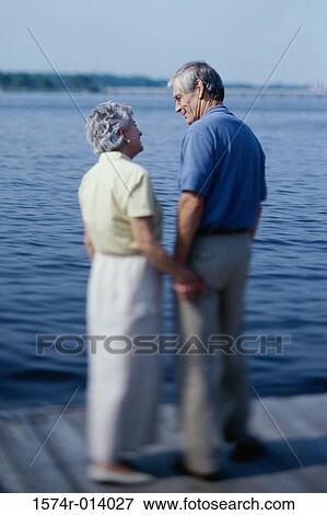 Stock Photo - Rear view of a senior couple standing on the dock. Fotosearch