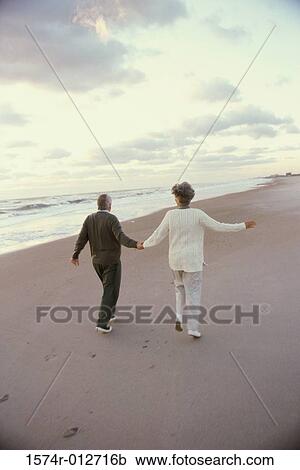 Rear view of a senior couple walking together on the beach View Large Photo Image Stock Image - Rear view of a senior couple walking together on the beach. Fotosearch