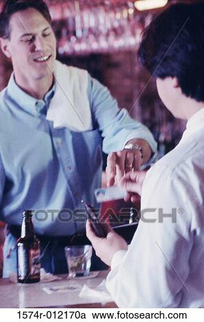 Rear view of a young man and a bartender at a bar View Large Photo Image Stock Image - Rear view of a young man and a bartender at a bar. Fotosearch