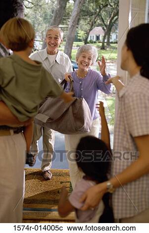 Rear view of parents with their two children receiving their grandparents View Large Photo Image Stock Image - Rear view of parents with their two children receiving their grandparents. Fotosearch