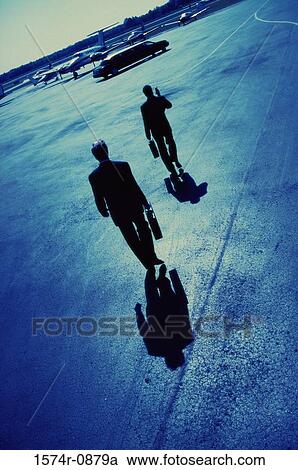 Rear view of two businessmen walking in an airport View Large Photo Image Stock Image - Rear view of two businessmen walking in an airport. Fotosearch