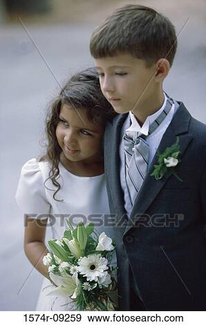 Stock Photo - Ring bearer standing holding a bouquet of flowers. Fotosearch