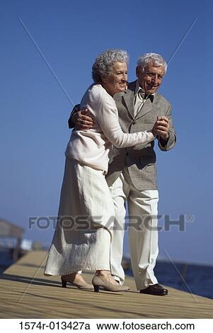 Stock Image - Senior couple dancing on a pier. Fotosearch