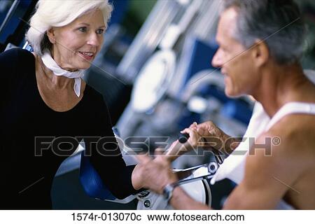Stock Image - Senior couple exercising in a gym. Fotosearch