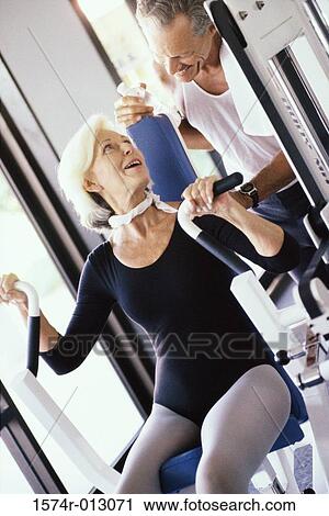 Stock Image - Senior couple exercising in a gym. Fotosearch