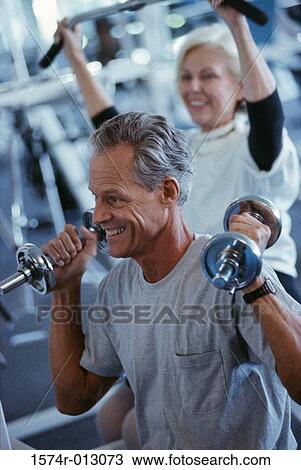 Stock Image - Senior couple exercising in a gym. Fotosearch