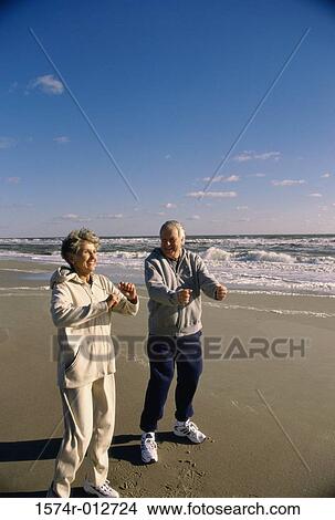 Picture - Senior couple exercising on the beach. Fotosearch