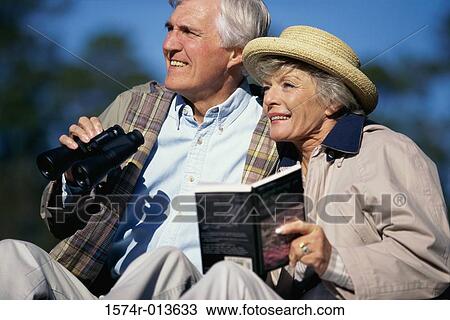 Senior couple holding binoculars and a book View Large Photo Image Stock Image - Senior couple holding binoculars and a book. Fotosearch