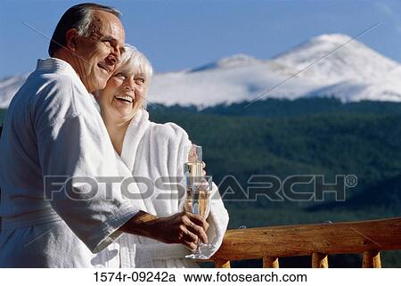 Stock Image - Senior couple holding glasses of champagne. Fotosearch