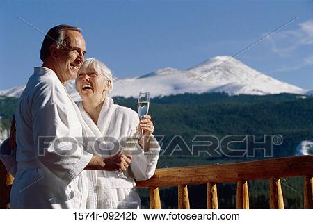 Stock Image - Senior couple holding glasses of champagne. Fotosearch
