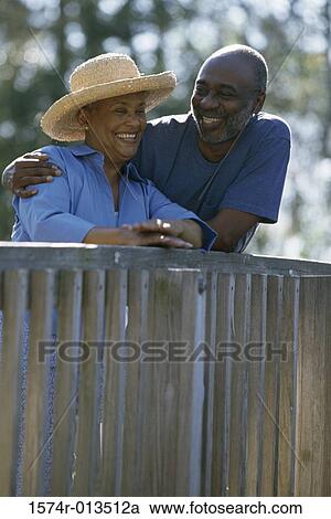 Stock Image - Senior couple leaning against a railing. Fotosearch