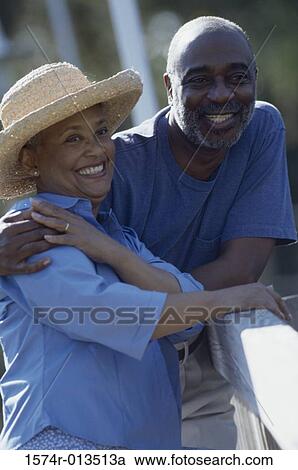 Stock Image - Senior couple leaning against a railing. Fotosearch