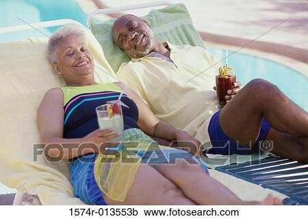 Senior couple lounging poolside View Large Photo Image Stock Image - Senior couple lounging poolside. Fotosearch